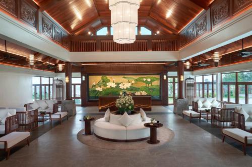 北宁Senna Wellness Retreat的大堂配有沙发、椅子和绘画作品