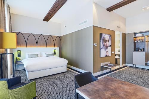 布雷达布雷达拿韶傲途格精选酒店的卧室配有一张床和一张桌子及椅子