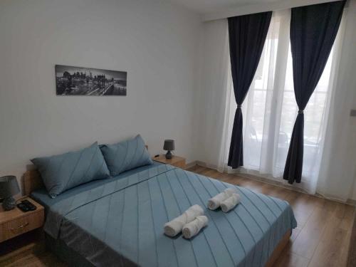 斯科普里Skopje Sky City 19th Floor Twin Apartments with Indoor Pool & Spa & Fitness Including in Price的一间卧室配有一张床,上面有两条毛巾