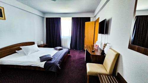 锡比乌伊甸酒店的配有一张床和一张书桌的酒店客房