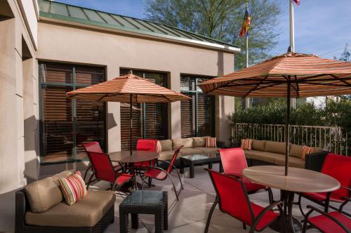 凤凰城菲尼克斯城机场北希尔顿花园旅馆的一个带桌椅和遮阳伞的庭院