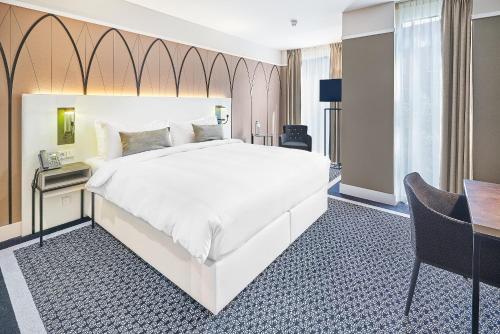 布雷达布雷达拿韶傲途格精选酒店的卧室配有一张白色大床和一张书桌