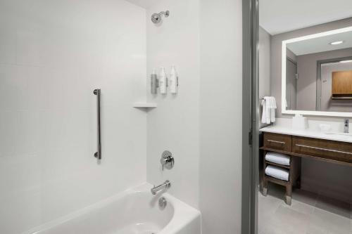 格林维尔Homewood Suites By Hilton Greenville, NC的白色的浴室设有浴缸和水槽。