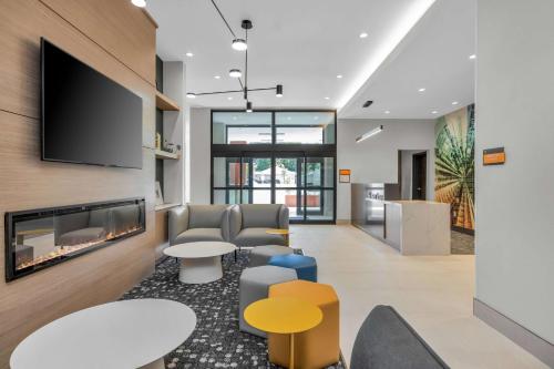 圣何塞La Quinta Inn & Suites by Wyndham San Jose Silicon Valley的一个带壁炉和电视的办公大厅