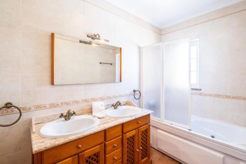 阿尔布费拉Villa Isabella的浴室设有2个水槽、浴缸和镜子