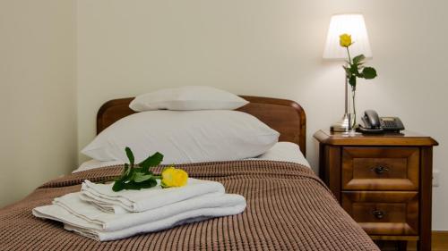 华沙拉齐恩科斯基酒店的一间卧室配有一张带毛巾的床和一部电话