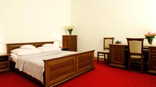 华沙拉齐恩科斯基酒店的卧室配有一张床、一张桌子和椅子