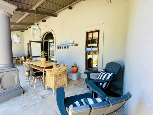 博福特西The Merino Guest House - B&B的庭院配有木桌和椅子