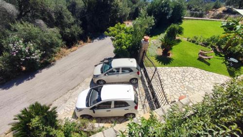 帕莱欧卡斯提撒Villa Amaryllis的2辆汽车停在围栏旁边的路上
