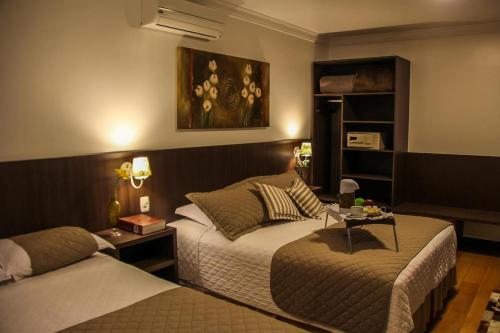 格拉玛多Hotel Premium的酒店客房设有两张床和一张桌子。