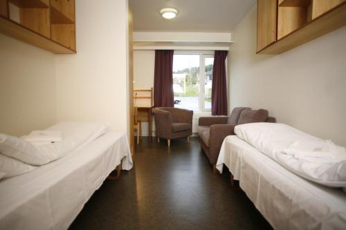 弗勒Førde Sommarhotell的一间医院间,配有两张床和椅子