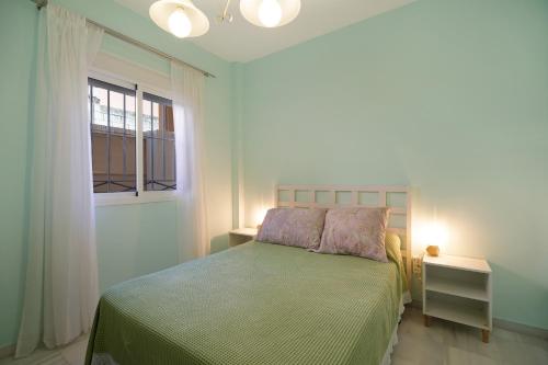 桑卢卡尔-德巴拉梅达San jeronimo的一间卧室配有一张带绿色床罩的床和窗户。