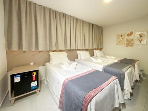 帕图斯Hotel Haki的酒店客房设有三张床和电视。