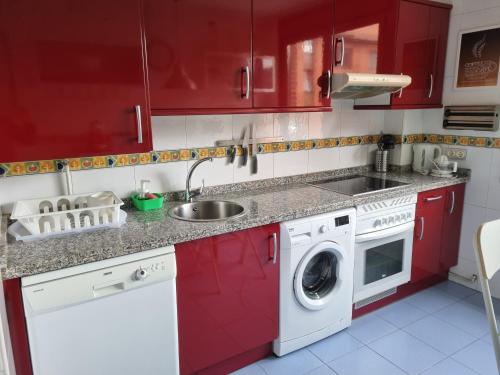 奥维多Piso zona hospital 7 personas的一间带红色橱柜和洗衣机的厨房