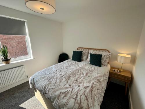 曼彻斯特Salford Townhouse 3 BR Home的一间卧室配有一张床、床头柜和窗户