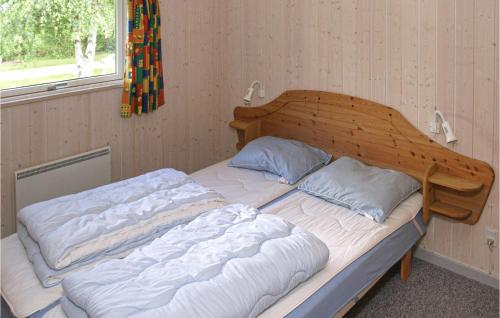 福旺3 Bedroom Cozy Home In Frvang的木头床头板的房间里一张床位