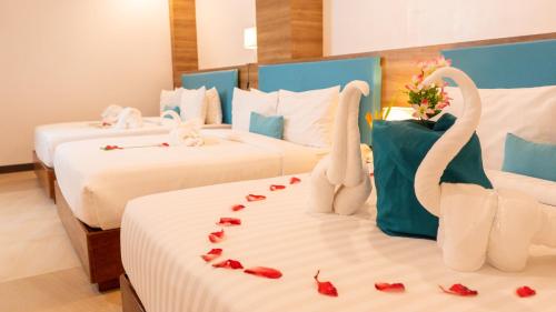长滩岛Boracay Sea View Hotel的酒店客房带两张床,有着天鹅装饰。