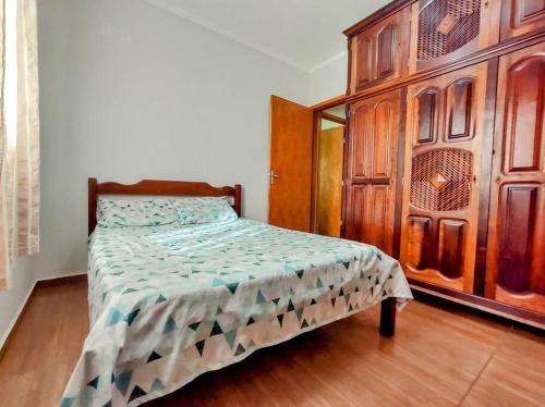 伊塔茹巴Básico e Aconchegante的一间卧室配有一张床和一个木制橱柜