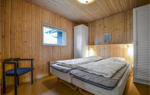 埃贝尔托夫特Amazing Home In Ebeltoft With Sauna的卧室配有木墙内的一张床