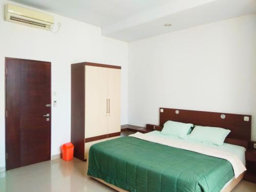 班图尔Omah Dixy Family Homestay by FH Stay的一间卧室配有一张带绿毯的大床