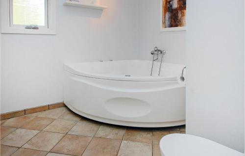 ÅrøsundAmazing Home In Haderslev With Kitchen的浴室铺有瓷砖地板,配有白色浴缸。