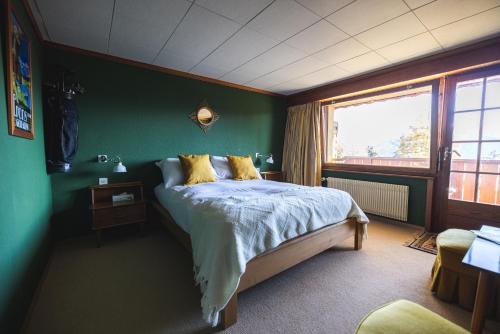 克莱恩 蒙塔纳Colorado Riders Chalet的一间卧室设有一张床和绿色的墙壁