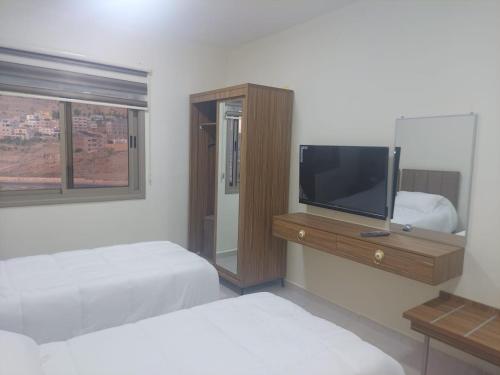 瓦迪穆萨Albasha的一间卧室配有两张床和一台平面电视