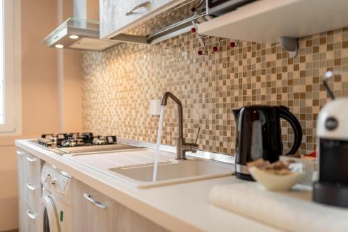 佛罗伦萨Dante Experience Apartment的厨房柜台设有水槽、炉灶和水槽