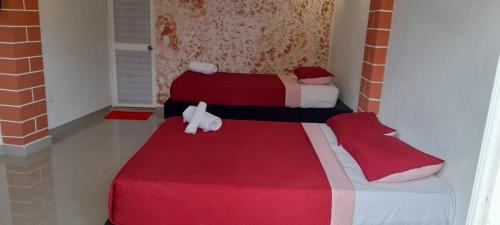 圣安德烈斯POSADA HIGH TIDE的一间设有两张红色和白色毯子的房间