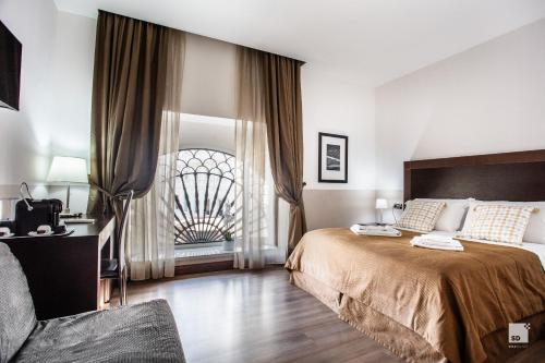 罗马那锡那里精品酒店的一间卧室设有一张大床和一个窗户。
