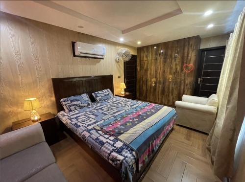 拉合尔Luxury Private Top Floor Apartment in Heart of Bahria Town的一间卧室配有一张床、一张沙发和一把椅子