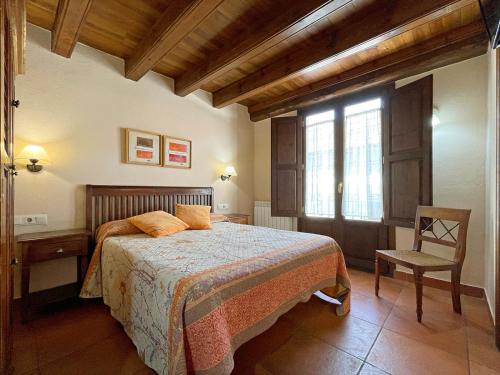 伊萨瓦Casa Rural juaningratxi的卧室配有床、椅子和窗户。
