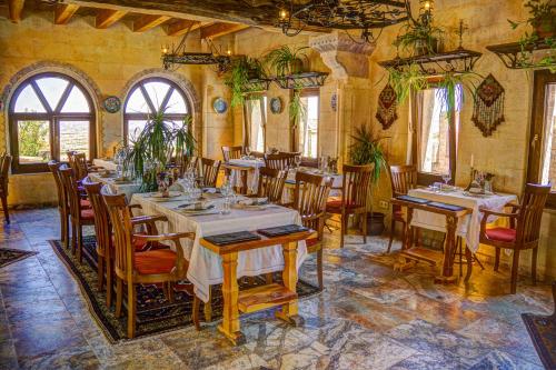 乌奇希萨尔Petra Inn Cappadocia的一间在房间内配有桌椅的餐厅