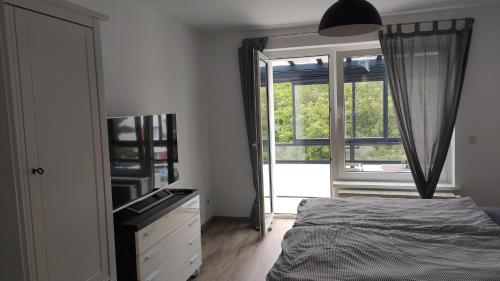 罗斯托克Wohnung Meeresbrise 48 qm mit Balkon的一间卧室配有一张床、一个梳妆台和一扇窗户。