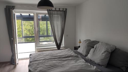 罗斯托克Wohnung Meeresbrise 48 qm mit Balkon的一间卧室设有一张床和一个大窗户