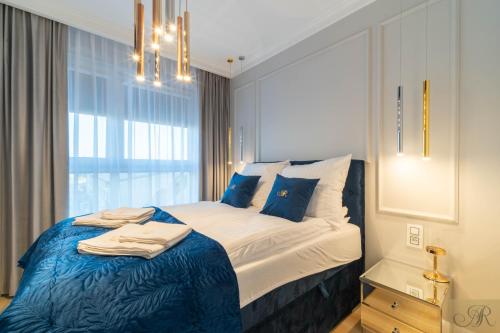 马佐夫舍地区明斯克Apartament Rosa Stacja Mińsk的一间卧室配有一张带蓝色床单的床和一扇窗户。
