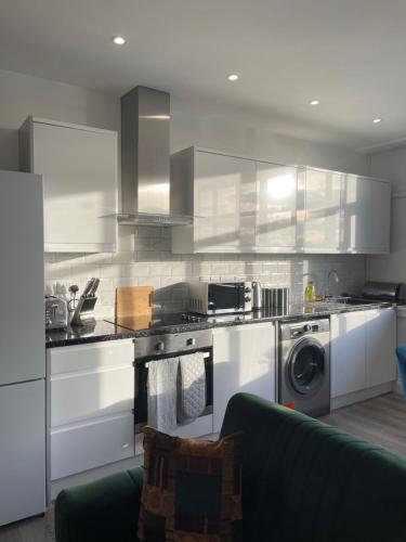 弗特威克Flitwick Luxury 3 Bedroom Apartment的厨房配有白色橱柜和炉灶烤箱。