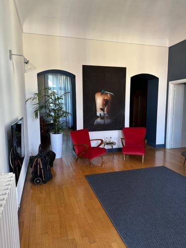里沃利Casa Piolti Rivoli的客厅配有红色椅子和墙上的绘画