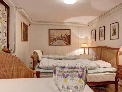 伦讷2 person holiday home in R nne的一间卧室配有一张床和一张带花瓶的桌子