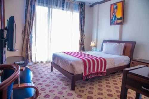 基加利Hotel Karisimbi的一间卧室设有一张床和一个大窗户