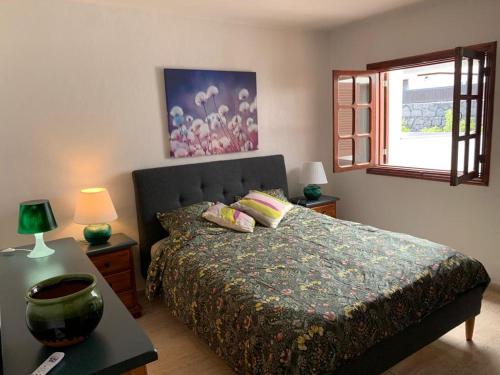 科斯塔特吉塞One bedroom bungalow Playa Bastian Costa Teguise的一间卧室配有一张床、一张桌子和一个窗户。