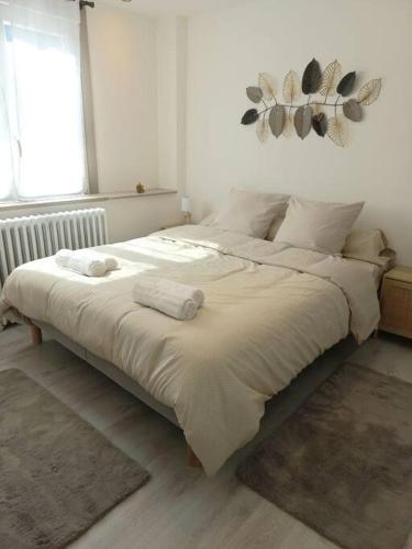 勒米尔蒙Appartement Les Géraniums的一间卧室配有一张带白色床单的大床