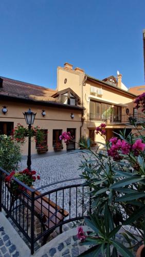 圣安德烈Red Lion Pub & Apartments Szentendre的带阳台的建筑和鲜花庭院