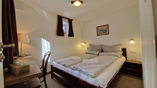 圣安德烈Red Lion Pub & Apartments Szentendre的一间卧室配有一张床和一张带台灯的桌子