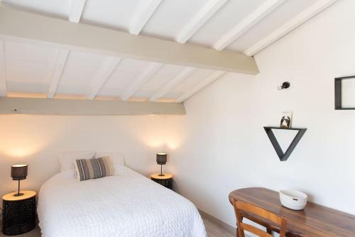 圣洛贝斯Villa Saint Loubès的卧室配有白色的床和木桌
