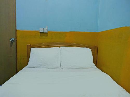 名古屋SPOT ON 92985 Mitra Homestay的一张带两个白色枕头的床