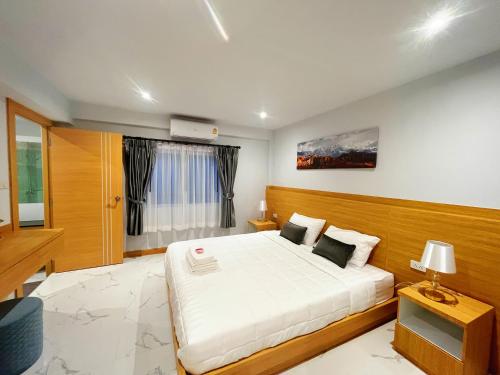 南芭堤雅Pattaya Aqua Villa - Pool - Kitchen - BBQ - Smart TV的卧室设有一张白色大床和一扇窗户。