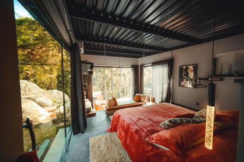 彼得罗波利斯Cabana Secreta的一间卧室设有一张大床和一个大窗户
