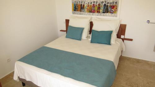 圣玛丽亚Ocean Roof的一间卧室配有一张带两个蓝色枕头的床