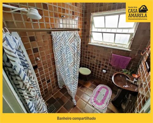 布卢梅瑙Casa Amarela Blumenau Hospedagem Alternativa的瓷砖浴室设有卫生间和窗户。